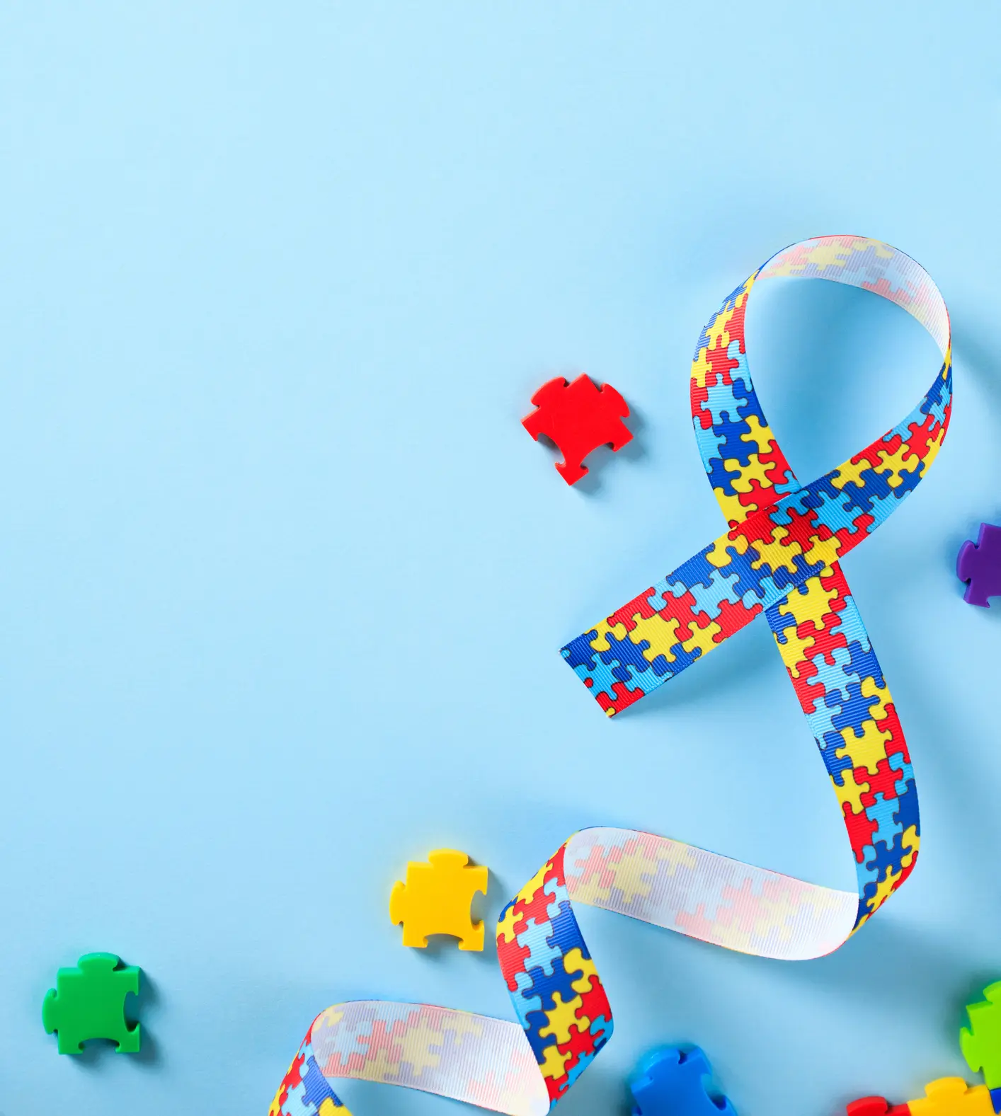 An autism awareness ribbon surrounded by puzzle pieces