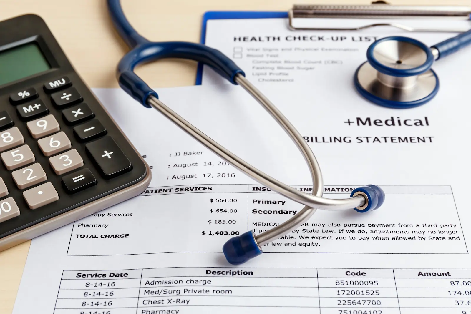 A close-up of medical bills, a stethoscope, and a calculator